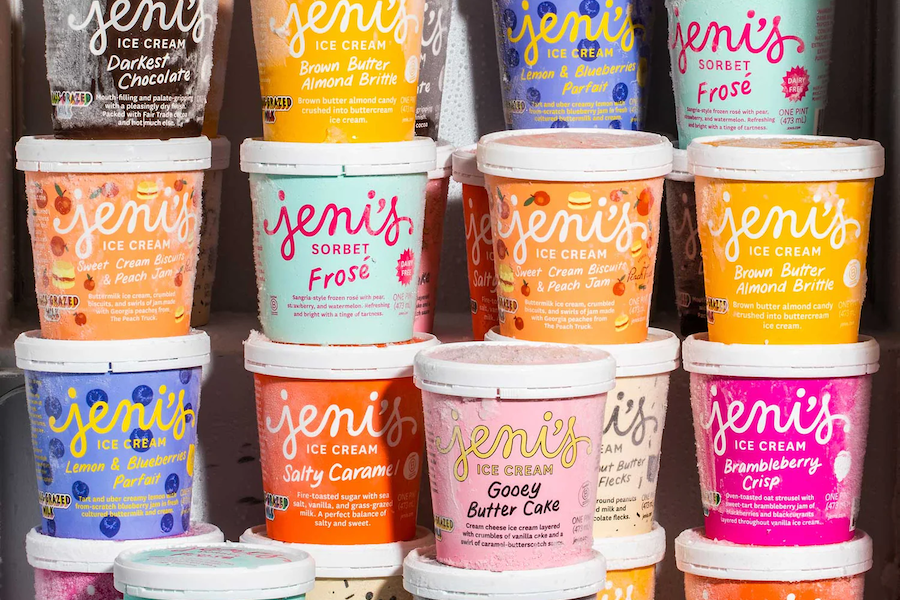 A freezer filled with colorful pints of Jeni's Ice Cream, neatly stacked, showcasing various flavors such as Darkest Chocolate, Salty Caramel, Lemon & Blueberries Parfait, and Gooey Butter Cake.