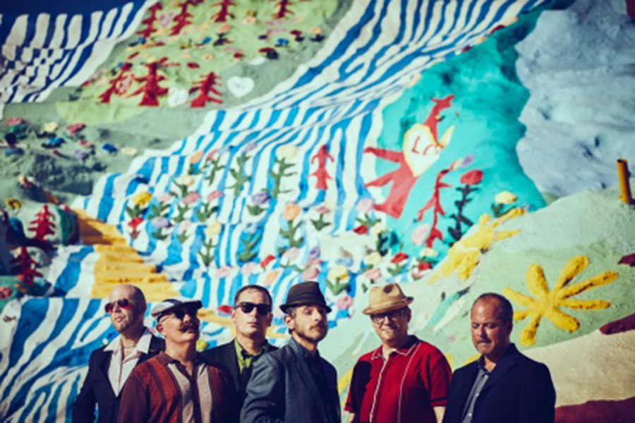 The Slackers standing in front of colorful background 